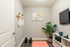 Bonus Room - Den/ Flexible Space Chic home gym with minimalistic decor, featuring a sleek shelf, vibrant potted plant, and modern equipment.