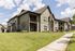Charming modern apartment community with lush green lawns and picturesque palm trees under a bright blue sky.