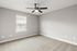 Bright, spacious room with plush carpet, sleek ceiling fan, and elegant window blinds perfect for modern living.
