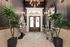 Chic entrance with modern geometric decor, lush potted plants, and unique art features, exuding elegance and style.