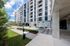 Tides at River Rapids apartments building exterior with modern architecture, lush greenery, and spacious pathway.