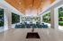 Luxurious outdoor lounge area with elegant wooden ceiling, vibrant seating, and lush garden views.