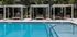 Luxurious outdoor pool area with stylish cabanas and lush greenery, perfect for relaxation and leisure.