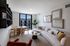 Enjoy everyday comfort in this contemporary living room with sleek porcelain tile flooring and expansive windows with natural lighting.