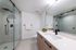 Modern bathroom featuring a sleek glass shower, elegant vanity with ample counter space, and contemporary fixtures.