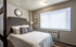 Spacious bedroom, with tasteful transparent divider that leads into the kitchen