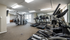 Westbury Apartments fitness center with great lighting , large mirrored wall and weight equipment.