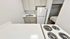 Chic kitchenette featuring a compact fridge, stove, sink, and open view into a welcoming bedroom.