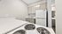 Modern, compact kitchen with sleek cabinetry and electric stove, ideal for efficient cooking.
