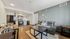 Inviting open-plan living room with modern kitchen and cozy furnishings, featuring sleek appliances and stylish decor.