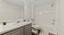 Bright, modern bathroom featuring a bathtub, sleek countertops, and stylish accessories.