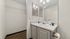 Modern bathroom with sleek fixtures, large mirror, and stylish countertop.