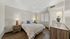 Elegant bedroom with a queen-size bed, stylish lamps, and modern wooden furniture.