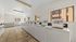 Bright and airy laundry room with multiple washing machines and ample natural light.