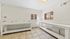 Sunlit laundry room with spacious counter space and tiled flooring.