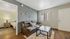 Inviting living room featuring a comfortable leather sofa, modern coffee table, and glimpse into a warmly lit bedroom.