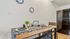Cozy dining area with a wooden table, black fridge, stylish decor, and succulent plants.
