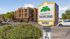 Exterior view of the Residence at Tropicana apartments with well-maintained parking area.