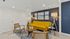 Contemporary living room with a vibrant yellow sofa, stylish art, and a cozy ambience.