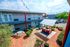 Colorful two-story apartment building with vibrant outdoor courtyard, featuring string lights and lush greenery.