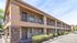 Charming two-story apartment building with modern stone accents and lush landscaping, offering a welcoming and well-maintained exterior.
