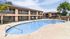 Inviting outdoor pool area in a modern apartment complex, highlighted by sunny skies and well-maintained landscaping.
