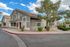 Charming apartment complex with modern architecture, lush landscaping, and inviting pathways under a picturesque blue sky.