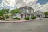 Charming two-story apartment building with a modern exterior, landscaped greenery, and ample parking in a tranquil neighborhood.