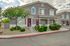 Charming two-story apartment building surrounded by lush green landscaping and modern architecture, perfect for comfortable living.