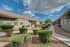 Charming apartment complex with manicured landscaping and a clear blue sky backdrop, offering a welcoming and serene environment.