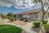 Charming residential complex with lush landscaping and modern architectural design, inviting pathways, and vibrant greenery under a picturesque blue sky.