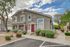 Charming two-story townhouse with modern design, surrounded by neatly trimmed greenery and a well-maintained walkway.