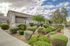 Charming apartment exterior with manicured landscaping and vibrant greenery under a beautiful sky.