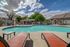 Inviting outdoor pool area with sleek lounge chairs under a vibrant blue sky, lush landscaping adding to the serene atmosphere.