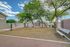 Inviting outdoor space featuring modern fitness equipment, lush green trees, and a serene bench for relaxation under the vibrant sky.