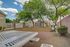 Charming outdoor park area with lush trees, benches, and exercise equipment, perfect for relaxation and fitness.