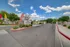 Welcoming entrance to Hidden Canyon Village with vibrant flags, lush landscaping, and a clear blue sky.