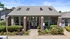 Charming brick apartment building entrance with lush landscaping and modern skylights.