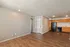 Charming open-concept living space featuring elegant wood flooring and a modern kitchen with sleek appliances.
