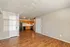 Inviting open-concept living space with warm wooden floors and a modern kitchen featuring sleek appliances.