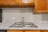 Elegant kitchen with gleaming granite countertops and a modern double sink, complemented by rich wooden cabinetry.