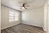 Bright and airy room with modern wood flooring and a sleek ceiling fan, perfect for a cozy personal retreat.