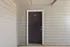 Inviting apartment entrance with modern siding and a sleek dark door, offering privacy and style.