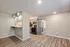 Chic open concept kitchen with modern fixtures, warm wood flooring, and natural lighting for a cozy atmosphere.