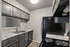 Chic kitchen with sleek gray cabinets, modern appliances, and elegant granite countertops.