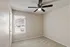 Bright bedroom featuring soft carpet, modern ceiling fan, and a large window with blinds inviting natural light.