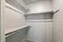Spacious and clean walk-in closet featuring double hanging rods and ample shelving.