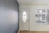 Inviting entryway with a chic oval windowed door and elegant contrast wall, blending modern style with natural light.