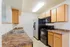 Modern kitchen with sleek black appliances, wooden cabinetry, and granite-style countertops offering ample workspace.