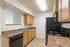 Modern kitchen with elegant granite countertops, sleek black appliances, and ample wooden cabinetry.